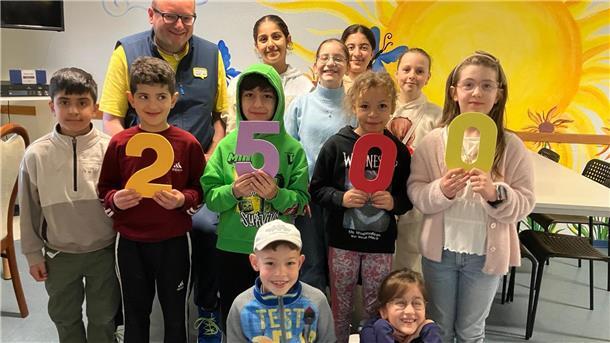 Ikea unterstützt das Projekt „Sonnenblume“ mit 2.500 Euro Kinder halten die Zahl 2.500 in die Kamera.
