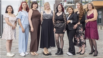 Acht Frauen stehen nebeneinander.
