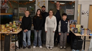 Schülerinnen und Schüler stehen vor Tischen mit Spenden 