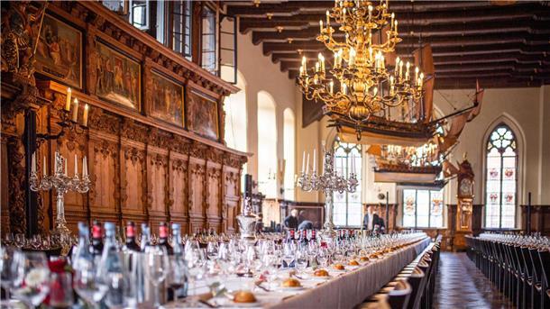 Blick in die Obere Rathaushalle vor der Mahlzeit während des Eindeckens der Tafeln mit Geschirr, Dekoration und Bestuhlung.
