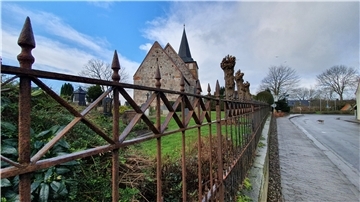 Blick in Richtung Kirche. Auf dem Kirchhof erinnert eine Gedenkschrift an den Kampf der Mulsumer Bauern gegen die Söldner des Erzstifts Bremen im Jahre 1524.