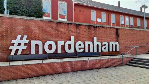Die Flutmauer vorm Nordenhamer Bahnhof mit dem Schriftzug "#nordenham“.