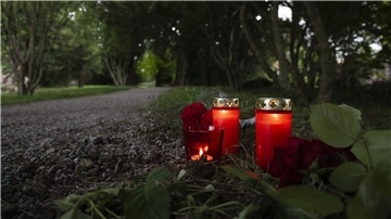 Blumem und Kerzen liegen im Park an dem Tatort im schweizerischen Männedorf.