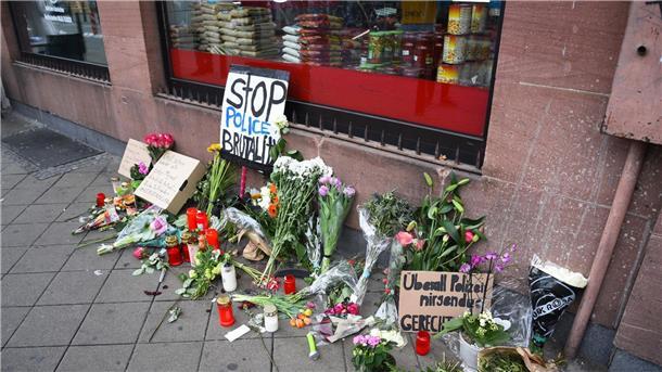 Prozess nach Polizeikontrolle - Beamte auf der Anklagebank Blumen, Kerzen und Schilder liegen in Mannheim an dem Ort, an dem ein Mann Anfang Mai 2022 nach einer Polizeikontrolle starb.