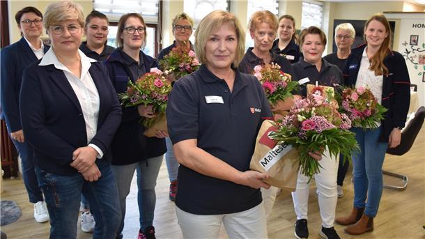 Senioren-WG entscheidet sich für die Malteser Blumen und Geschenke der Malteser gab es vor der ersten Dienstbesprechung auch für die Pflegekräfte (von links): Uljana Kalinowski und Irina Scheifel von der Pflegedienstleitung des Ambulanten Pflegedienstes der Malteser Wesermarsch, die Pflegekräfte Larissa Bohlen, Jessica Hahner, Helga Prophet, Heike Hatscher, Meike Bolting, Vanessa Reimers, Valentina Spiekermann und Heikea Bruns sowie die Dienstleiterin Netzwerk Pflege der Malteser im Oldenburger Land, Pia Kaling.
