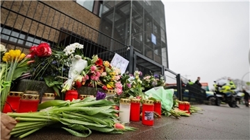 Blumen und Kerzen erinnern vor dem Eingangsbereich des Gemeindehauses in Hamburg an die Opfer der Amoktat.