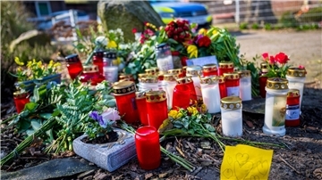 Blumen und Kerzen liegen vor einem Einfamilienhaus.