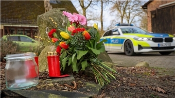 Blumen und Kerzen stehen vor einem Haus in Westervesede in der Gemeinde Scheeßel, in dem ein Mann geschossen haben soll.