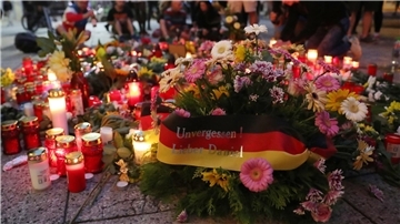 Blumen und Kerzen werden am Tatort in der Innenstadt von Chemnitz niedergelegt.