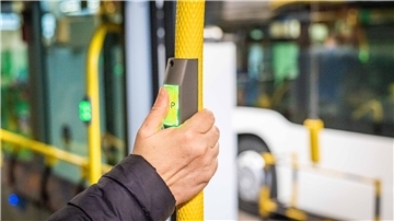 Hand drückt das Stopsignal in einem öffentlichen Bus