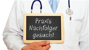 Ein Arzt hält ein Schild in der Hand.