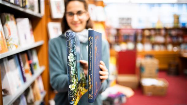 Buchrücken, die entzücken: Buchhändlerin Alexandra Köpping von der Buchhandlung Memminger in Bremerhaven zeigt ihr Lieblingsexemplar "Alle Farben des Lebens" von Autorin Lisa Aisato. Foto: Hartmann