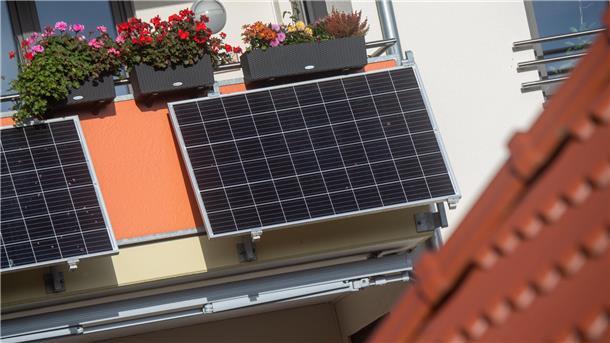 Solarmodule für ein sogenanntes Balkonkraftwerk hängen an einem Balkon