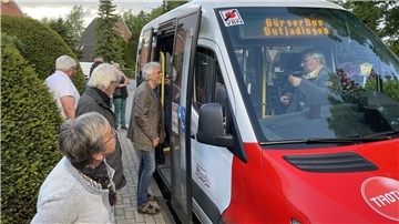 Einige Leute schauen sich einen Bürgerbus an.
