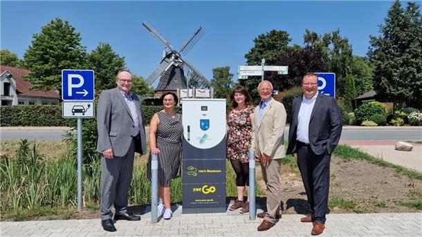 Bürgermeister Harald Stindt und Claudia Ottke vom Fachbereich Tiefbau der Gemeinde Stadland, Valerie-Manon Eppert vom Landkreis Wesermarsch, Tönjes Itgen vom Oldenburger Mobilitätsdienstleister EWE Go und Ralf von Dzwonkowski, Kommunalbetreuer der EWE NETZ (von links) haben die E-Ladesäule auf dem neuen Parkplatz an der Seefelder Mühle offiziell in Betrieb genommen.
