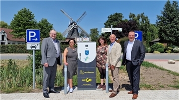 Bürgermeister Harald Stindt und Claudia Ottke vom Fachbereich Tiefbau der Gemeinde Stadland, Valerie-Manon Eppert vom Landkreis Wesermarsch, Tönjes Itgen vom Oldenburger Mobilitätsdienstleister EWE Go und Ralf von Dzwonkowski, Kommunalbetreuer der EWE NETZ (von links) haben die E-Ladesäule auf dem neuen Parkplatz an der Seefelder Mühle offiziell in Betrieb genommen.