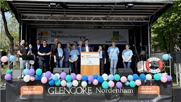 Es ist der Bürgermeister Nils Siemen zu sehen, der auf der Bühne des Quartierfestes allen Helferinnen und Helfern dankt.  