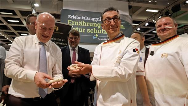 Özdemirs Messetour mit Birkensaft und „weniger Zickzack“ Bundesagrarminister Cem Özdemir und Berlins Regierender Bürgermeister Kai Wegner formen Brezeln beim Eröffnungsrundgang über das Messegelände der Grünen Woche.