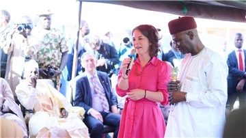 Bundesaußenministerin Annalena Baerbock spricht in Ngarannam, das 2015 von Boko Haram fast ganz zerstört und wieder aufgebaut wurde, mit Bewohnerinnen und Bewohnern.