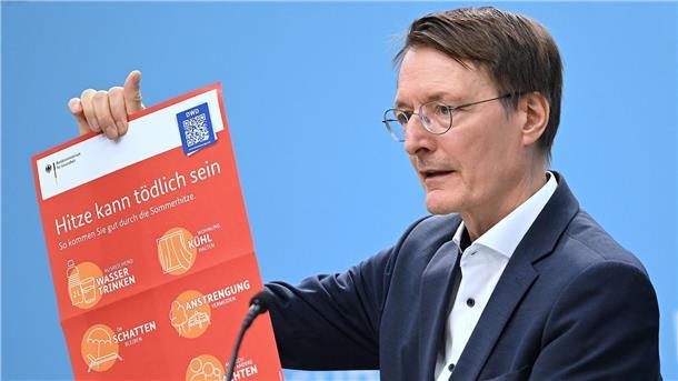 Mehr Vorbeugung gegen Hitzetote im Sommer Bundesgesundheitsminister Karl Lauterbach (SPD) hält ein Plakat zum Thema Hitzeschutz hoch.