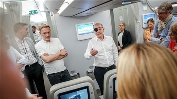 Bundeskanzler Olaf Scholz (r, SPD) und Finanzminister Christian Lindner (FDP) sprechen auf dem Flug nach Neu Dehli mit Journalisten.