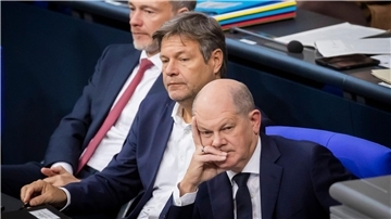 Bundeskanzler Olaf Scholz (SPD, r-l), Wirtschaftsminister Robert Habeck (Bündnis 90/Die Grünen) und Finanzminister Christian Lindner (FDP) verfolgen im Deutschen Bundestag die Debatte.