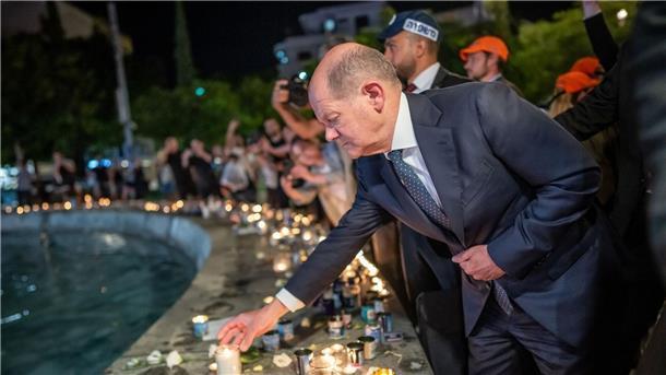 Bundeskanzler Olaf Scholz (SPD) steht bei seinem Solidaritätsbesuch in Israel mit einer Kerze am Dizengoff Square im Zentrum von Tel Aviv.