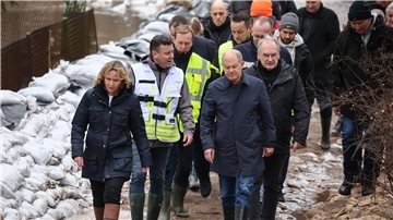 Bundeskanzler Olaf Scholz (vorne rechts) trägt bei seinem Besuch im Hochwassergebiet in Sangerhausen Gummistiefel.