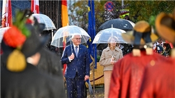 Bundespräsident Frank-Walter Steinmeier und seine Ehefrau Elke Büdenbender nehmen im strömenden Regen am landesüblichen Empfang durch die Tiroler Schützenkompanie teil.
