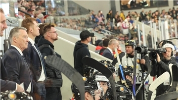 Bundestrainer Harold Kreis begrüßt Kameras in der Eishockey-Kabine.