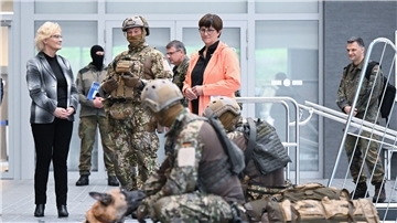 Bundesverteidigungsministerin Christine Lambrecht (l, SPD) sieht sich bei ihrem Besuch beim Kommando Spezialkräfte (KSK) in einer Schwimmhalle eine Ausbildungsübung mit einem Hund an.