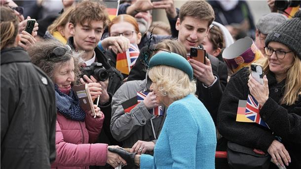 Jubelrufe und Fähnchen: Charles und Camilla in Berlin Camilla begrüßt die royalen Fans am Brandenburger Tor.