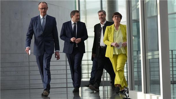 CDU-Chef Friedrich Merz, SPD-Chef Lars Klingbeil, CSU-Chef Markus Söder und die SPD-Vorsitzende Saskia Esken (v.l.n.r.) laufen nach einer Besprechung einen Gang entlang. Sie haben sich auf ein Sonderungspapier geeinigt. 