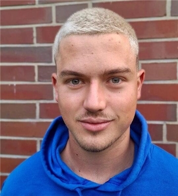 Porträtfoto von Christian Saathoff. Er trägt einen blauen Hoodie und kurze, blonde Haare.