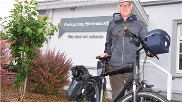 Christoph Heilscher mit seinem Fahrrad vor dem Gebäude der Kreiszeitung Wesermarsch