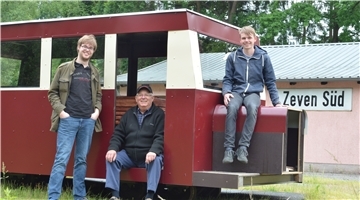 Christoph Klie, Karl Hillmer und Felix Czermack (von links) präsentieren stolz ihren Triebwagennachbau, der schon bald rund um das Vereinsgebäude der Zevener Eisenbahnfreunde Runden drehen soll.