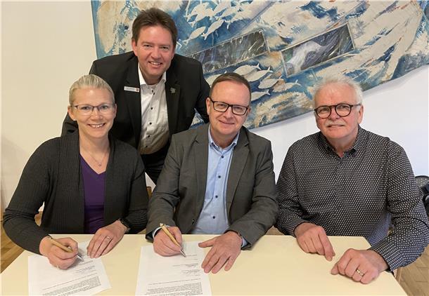Claudio Patrik Schrock-Opitz (Mitte) sowie der Aufsichtsratsvorsitzende Ralph Krümpelmann und die stellvertrtetende Vorsitzende Daniela Brockhoff-Bode unterzeichnen den Arbeitsvertrag, der alles besiegelt. Bürgermeister Axel Linneweber guckt ihnen dabei über die Schulter.
