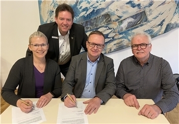 Claudio Patrik Schrock-Opitz (Mitte) sowie der Aufsichtsratsvorsitzende Ralph Krümpelmann und die stellvertrtetende Vorsitzende Daniela Brockhoff-Bode unterzeichnen den Arbeitsvertrag, der alles besiegelt. Bürgermeister Axel Linneweber guckt ihnen dabei über die Schulter.