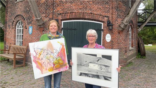 Neues Projekt zum Mitmachen: „Mein Bild“ in der Seefelder Mühle Zwei Frauen stehen vor einer Mühle. Sie halten jeweils ein großes Bild in den Händen.