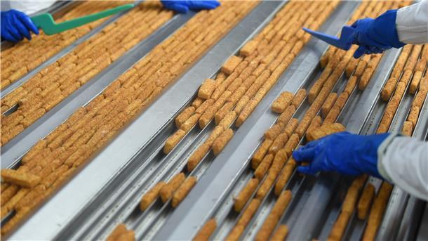 Coronabedingte Probleme bei der Lieferung von Rohfisch sorgen bei Frosta für Umstellungen in der Produktion. Die Mitarbeiter kommen nun verstärkt in jenen Bereichen zum Einsatz, wo Pfannengerichte ohne Fisch und Gemüsemischungen hergestellt werden. Foto: Jaspersen/dpa