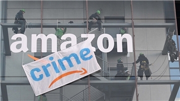 "Crime" statt Prime: Greenpeace-Aktivisten hängen während des Black Fridays 2022 ein Transparent mit der Aufschrift «crime» an der Zentrale von Amazon Deutschland in München auf. Amazon steht immer wieder in der Kritik. Darauf reagiert der Konzern mit Image-Werbung.