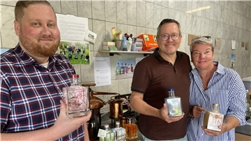 Zwei Männer und eine Frau mit Gin-Flaschen in der Hand. Daryn, Dirk und Birthe Vowinkel betreiben Norgin