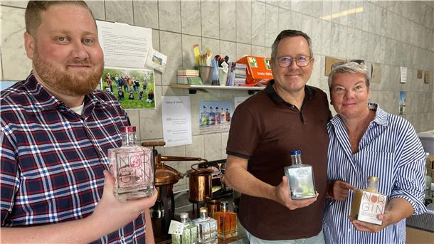 Zwei Männer und eine Frau mit Flaschen in der Hand. Daryn, Dirk und Birthe Vowinkel sind Norgin. Mit ihrem Gin haben sie eine erstaunliche Erfolgsgeschichte geschrieben.