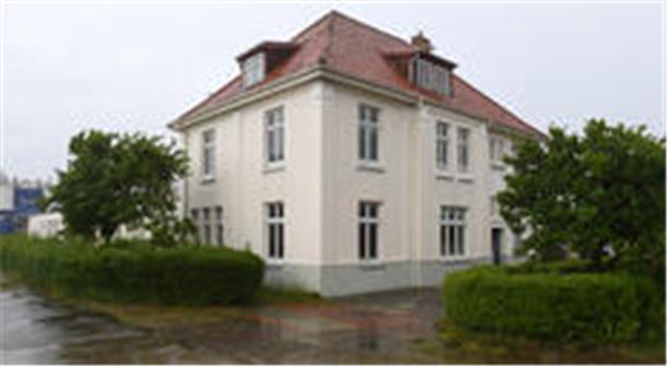 Gebäude mit Büschen und Bäumen. 