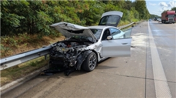 ein stark beschädigtes Auto steht auf einer Autobahn