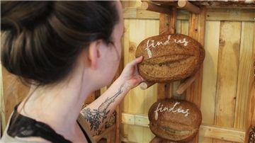 Eine Frau hält ein Brot in der Hand