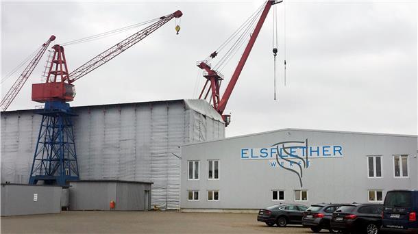 Das Firmenlogo der Elsflether Werft ist auf einer Halle angebracht.