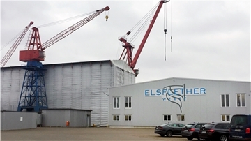 Das Firmenlogo der Elsflether Werft ist auf einer Halle angebracht.