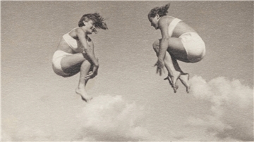 Historisches Foto zweier Frauen mitten im Sprung mit angezogenen Beinen