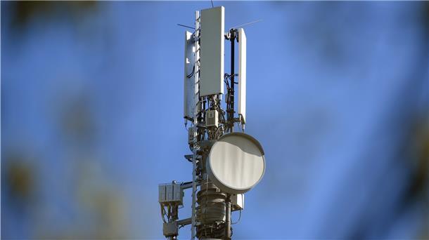 Ein Sendemast für Mobilfunk vor blauem Himmel.